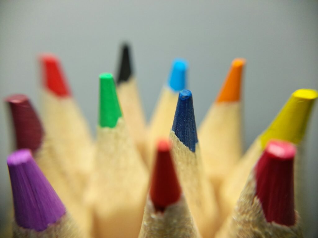 a group of colored pencils sitting next to each other